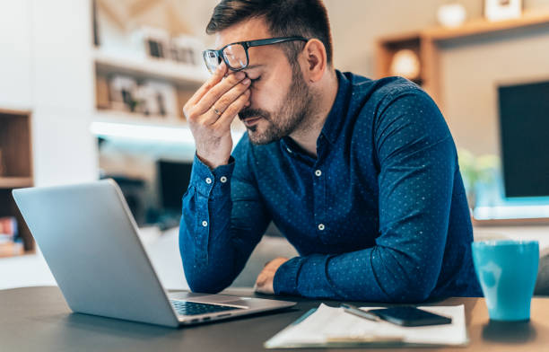 man rubbing his eyes